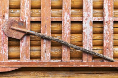 Eski bir ahşap ahır duvarına paslı metal kürek