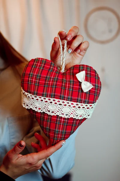 En flicka har en leksak röd hjärta — Stockfoto