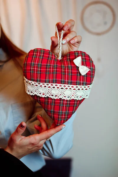 En flicka har en leksak röd hjärta — Stockfoto