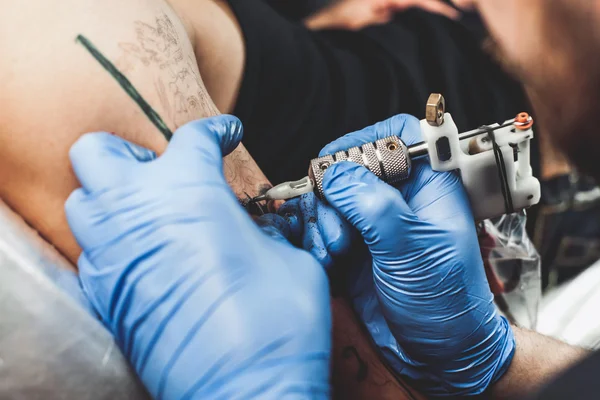 Mestre tatuador faz a tatuagem — Fotografia de Stock