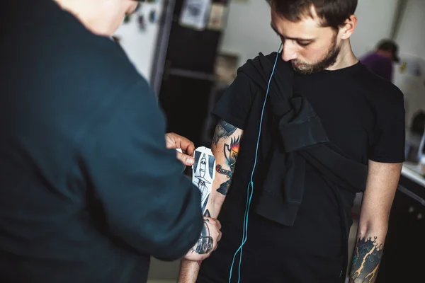 Master tattoo artist showing process