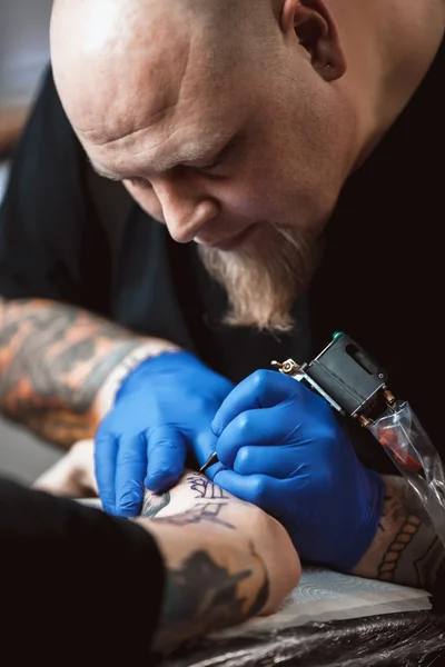 Maestro tatuatore fa un tatuaggio sulla pelle — Foto Stock