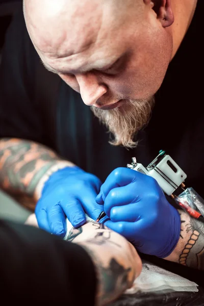 Master tattooist gör en tatuering på huden — Stockfoto