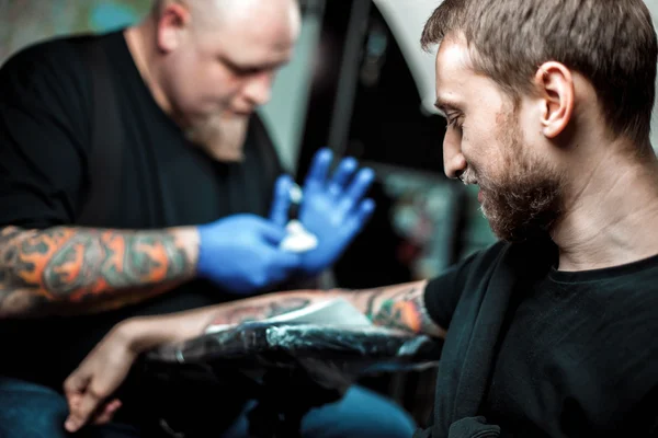Mestre tatuador faz uma tatuagem na pele — Fotografia de Stock