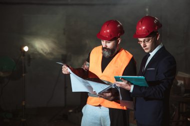 Yönetmen takım elbise ve kask ve tulum işçi