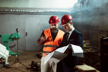 Yönetmen takım elbise ve kask ve tulum işçi