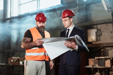 Yönetmen takım elbise ve kask ve tulum işçi