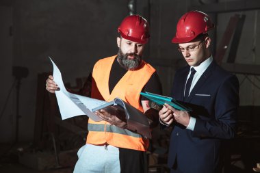 Yönetmen takım elbise ve kask ve tulum işçi