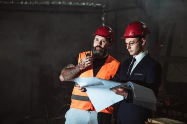 Yönetmen takım elbise ve kask ve tulum işçi