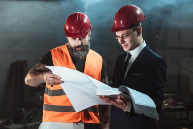 Yönetmen takım elbise ve kask ve tulum işçi