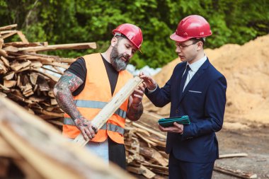 Yönetmen takım elbise ve kask ve tulum işçi