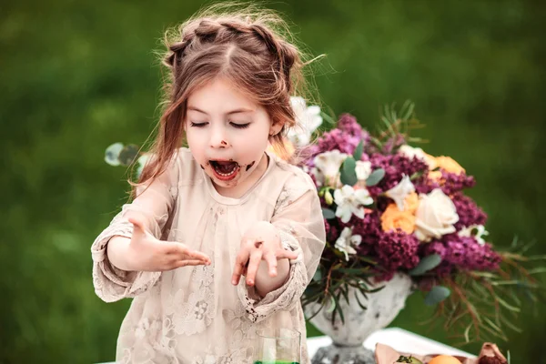 Niña come pastel de chocolate en la naturaleza en un picnic —  Fotos de Stock