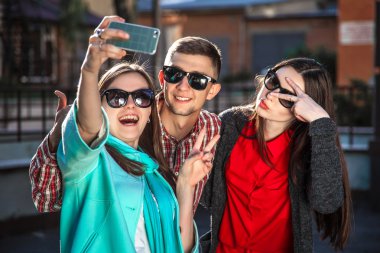 iki genç kadın ve selfie ile cep telefonu alarak adam