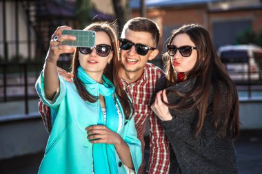 iki genç kadın ve selfie ile cep telefonu alarak adam