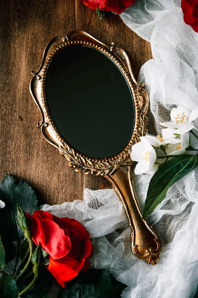 Beautiful a vintage mirror with flowers on wooden background — Stock Photo, Image