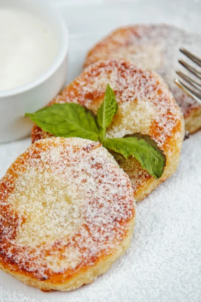 Rebanada de pastel de queso decorado con hoja de menta y salsa en el plato blanco — Foto de Stock