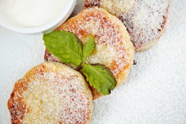 nane yaprağı ve beyaz tabakta soslu Cheesecake dilim süslenmiş