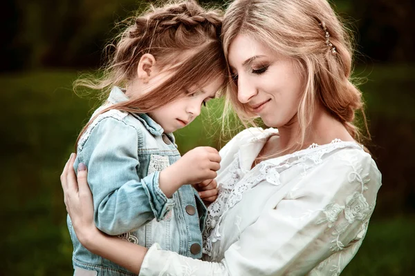 Una madre y un niño abrazándose y divirtiéndose en la naturaleza — Foto de Stock