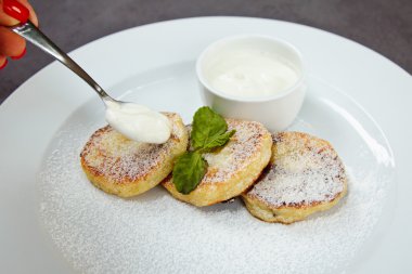 nane yaprağı ve beyaz tabakta soslu Cheesecake dilim süslenmiş