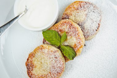 nane yaprağı ve beyaz tabakta soslu Cheesecake dilim süslenmiş