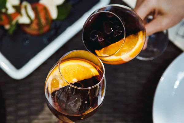 Casal no restaurante segurando copos de vinho tinto e bater-lhes sobre a mesa — Fotografia de Stock