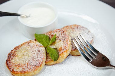 nane yaprağı ve beyaz tabakta soslu Cheesecake dilim süslenmiş