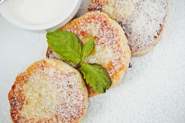 nane yaprağı ve beyaz tabakta soslu Cheesecake dilim süslenmiş