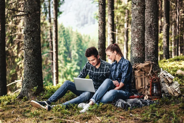 Birkaç oturma ve ormanın içinde laptop bakarak turistler. Aktif dinlenme kavramı — Stok fotoğraf