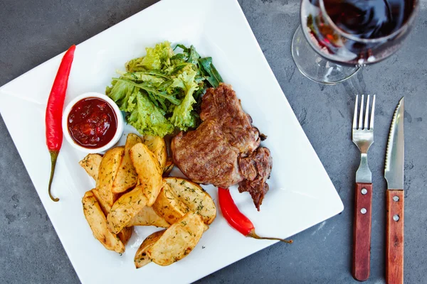 Hermosas papas fritas en coreano y filete de ribeye con una copa de vino tinto — Foto de Stock