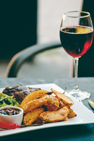 Beautiful potatoes fried in Korean and ribeye steak with a glass of red wine — Stock Photo, Image