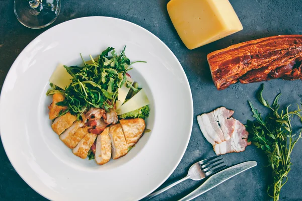 Salada Caesar com frango e verduras na mesa preta — Fotografia de Stock