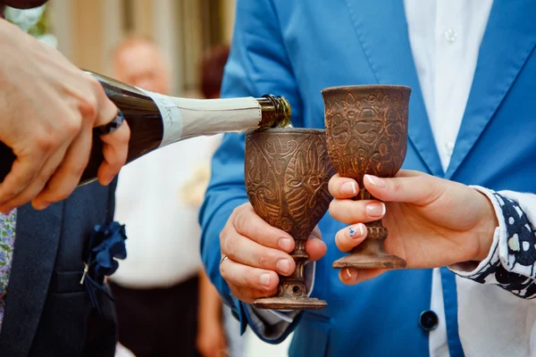 Une paire de jeunes mariés tenant des verres en bois vintage avec champagne — Photo