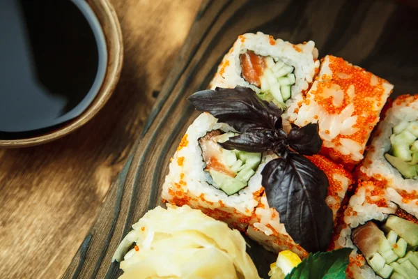 Bela comida chinesa e rolos de sushi em fundo de madeira — Fotografia de Stock