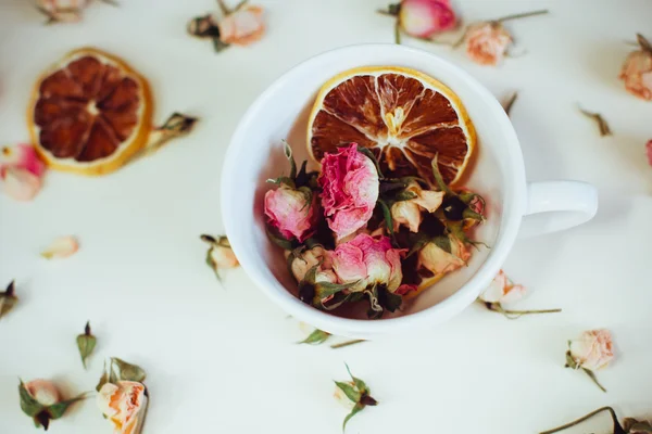 Beautiful background with roses and dried flowers dried round slices of lemon laid on a white background