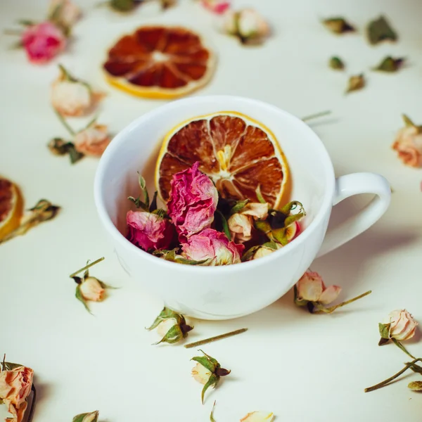 Schöner Hintergrund mit Rosen und getrockneten Blumen getrocknete runde Zitronenscheiben auf weißem Hintergrund gelegt — Stockfoto