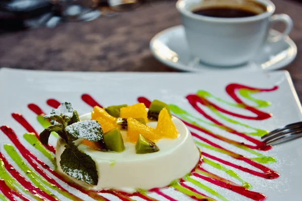 Photo de panna cotta italien dessert avec des tranches de kiwi, orange et feuille de menthe — Photo