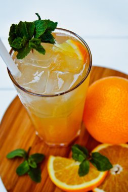 Ahşap masaüzerinde portakal ve nane ile soğuk içecek bardak. Buzlu çay