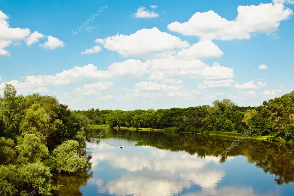 Beautiful Forest lake under blue cloudy sky