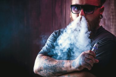 Güneş gözlüğü vaping sakallı adam