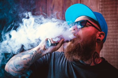 Güneş gözlüğü vaping sakallı adam