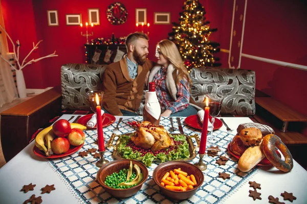 Schönes Paar in einem geschmückten Zimmer mit Weihnachtsbaum. — Stockfoto