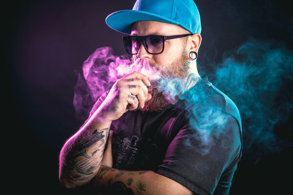 Man with beard  in sunglasses vaping