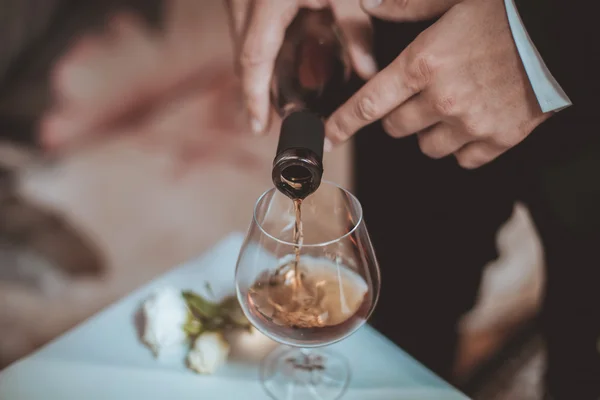 Hände gießen Glas Wein ein — Stockfoto