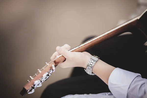 Руки жениха с гитарой — стоковое фото