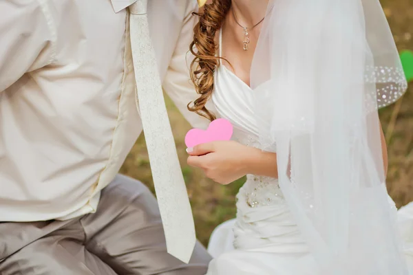 Ženich a nevěsta drží srdce — Stock fotografie