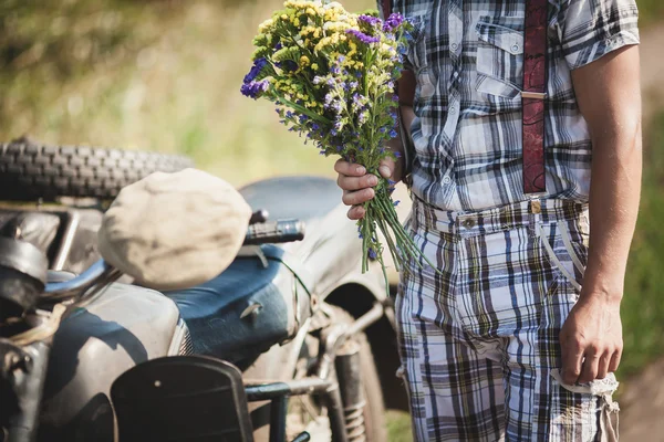 Muž s květinami a jeho kolo — Stock fotografie