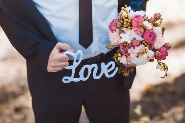 Bruidegom houden het woord liefde — Stockfoto
