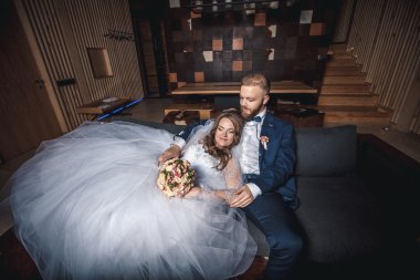 Mutlu gelin ve damat kanepede oturan