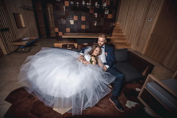 Ευτυχισμένη νύφη και ο γαμπρός κάθεται στον καναπέ — Φωτογραφία Αρχείου