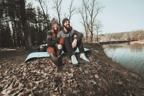 Joyeux couple assis sur la rive du lac — Photo